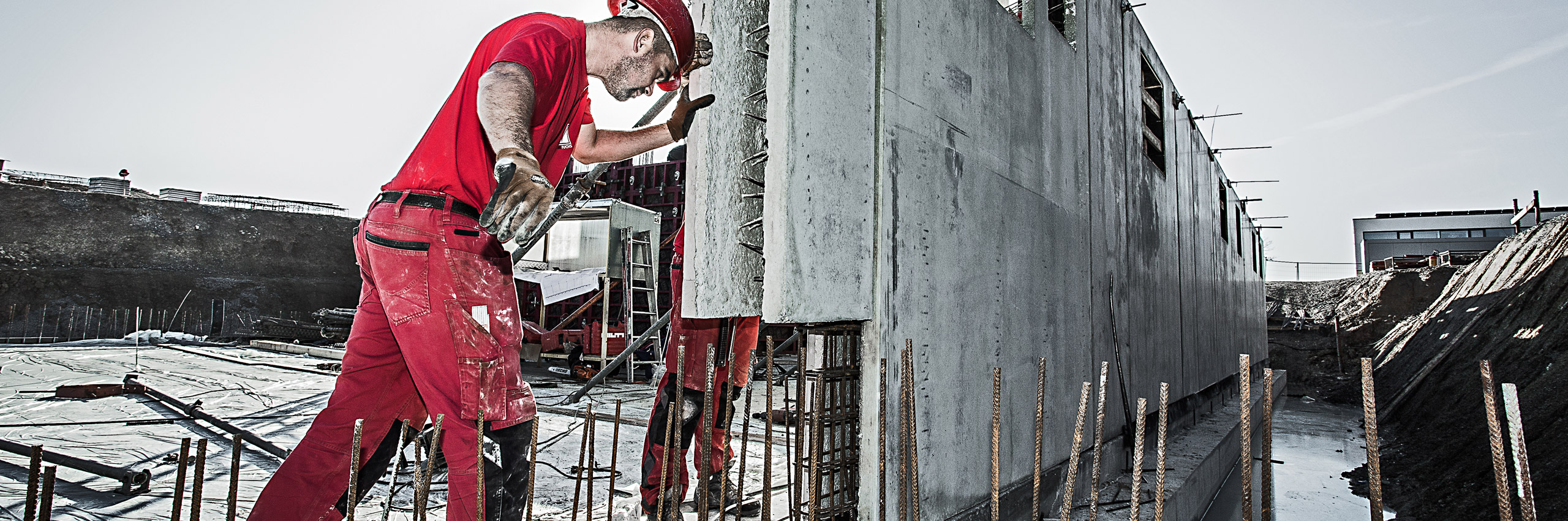 Ein Mitarbeiter justiert Betonfertigteile, nachdem diese aus dem Betonwerk geliefert worden. 